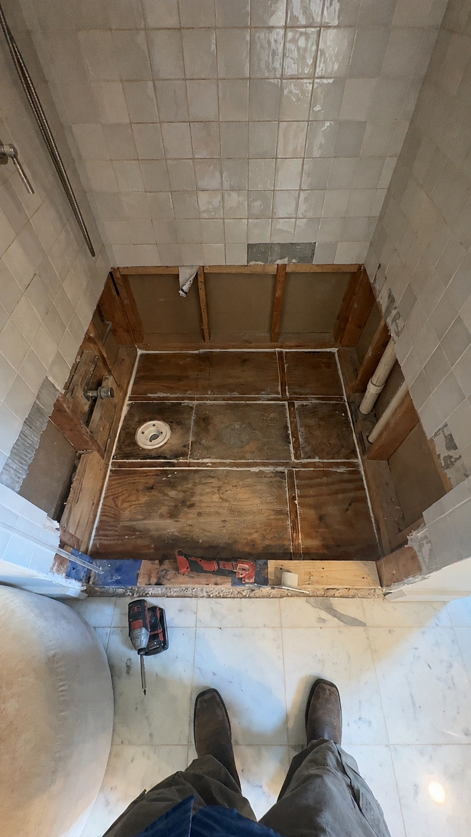 Existing shower floor opened for new drain and shower pan installation